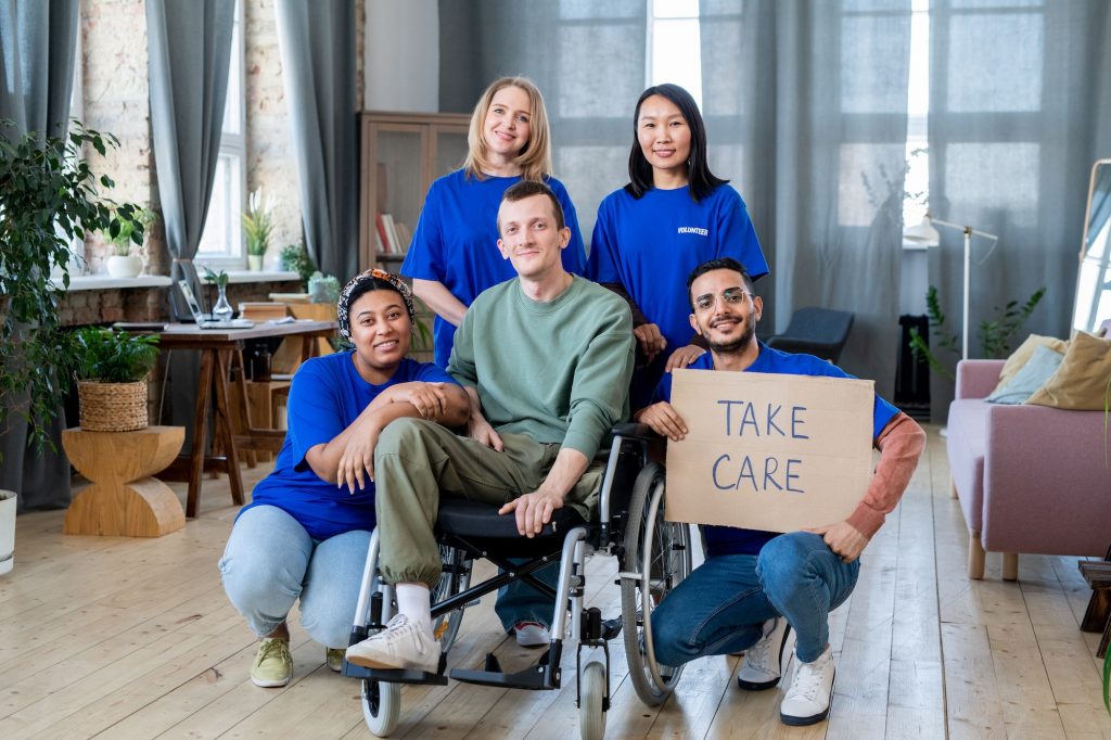 A group of young volunteers and disable guy