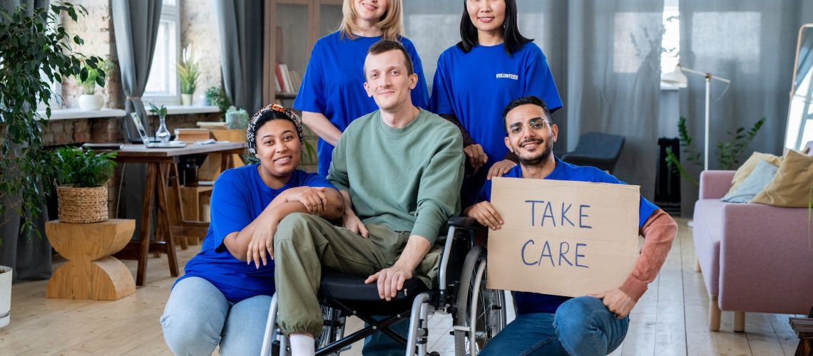 A group of young volunteers and disable guy