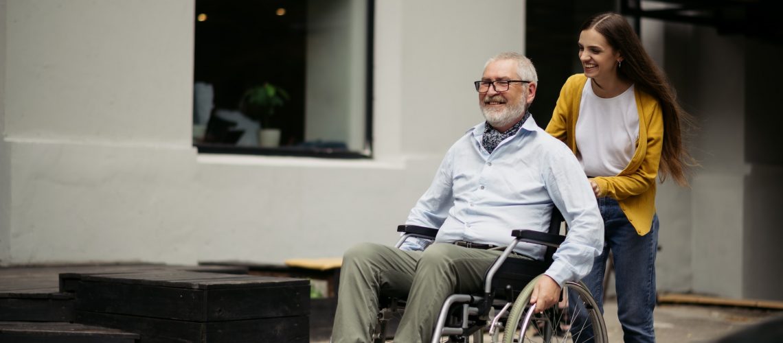 Daughter and disabled father go for a walk