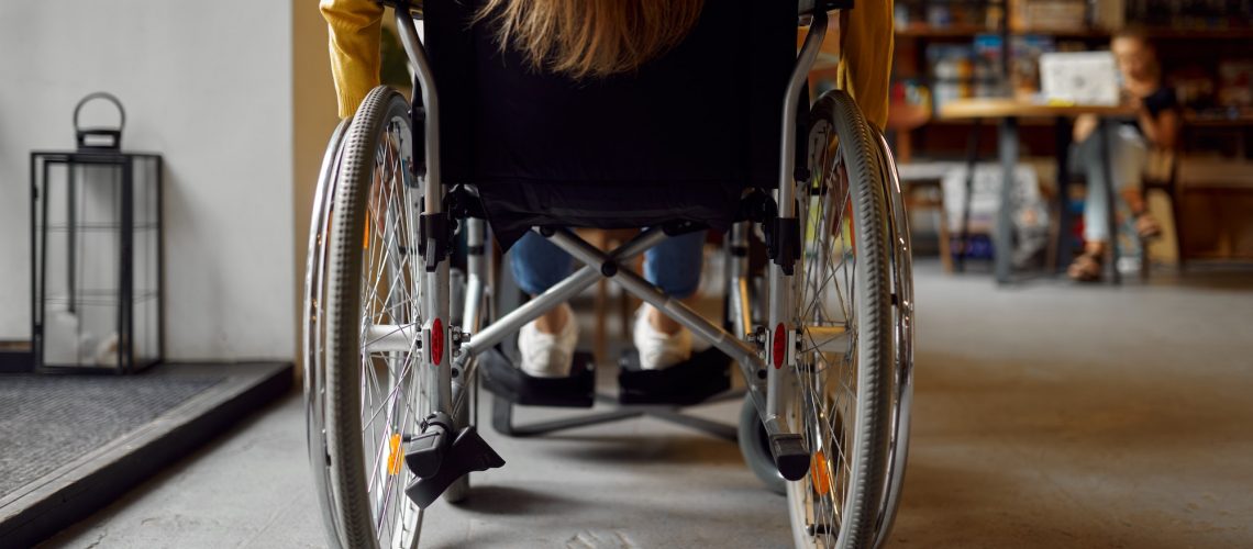 Disabled female student in wheelchair, back view