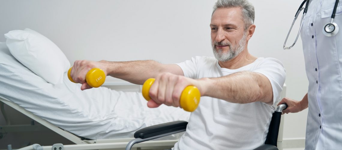 Disabled person doing strength training exercise with physiotherapist