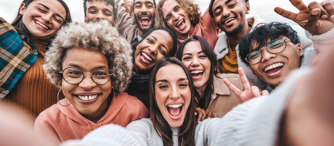 Multicultural community of young people smiling together at camera